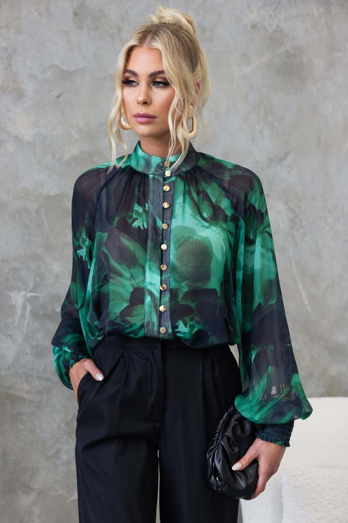 Orazio Top featuring a high neckline, button-up front, and floral chiffon design, styled with black pants.
