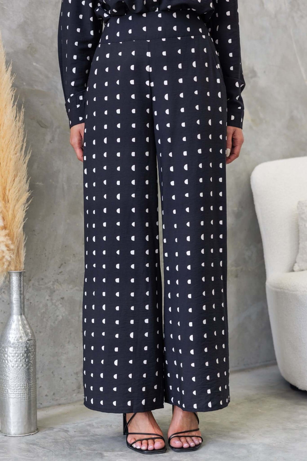 Marion Pants in black with white print; mid-high waist, elastic back, wide leg, and textured fabric; perfect for casual occasions.