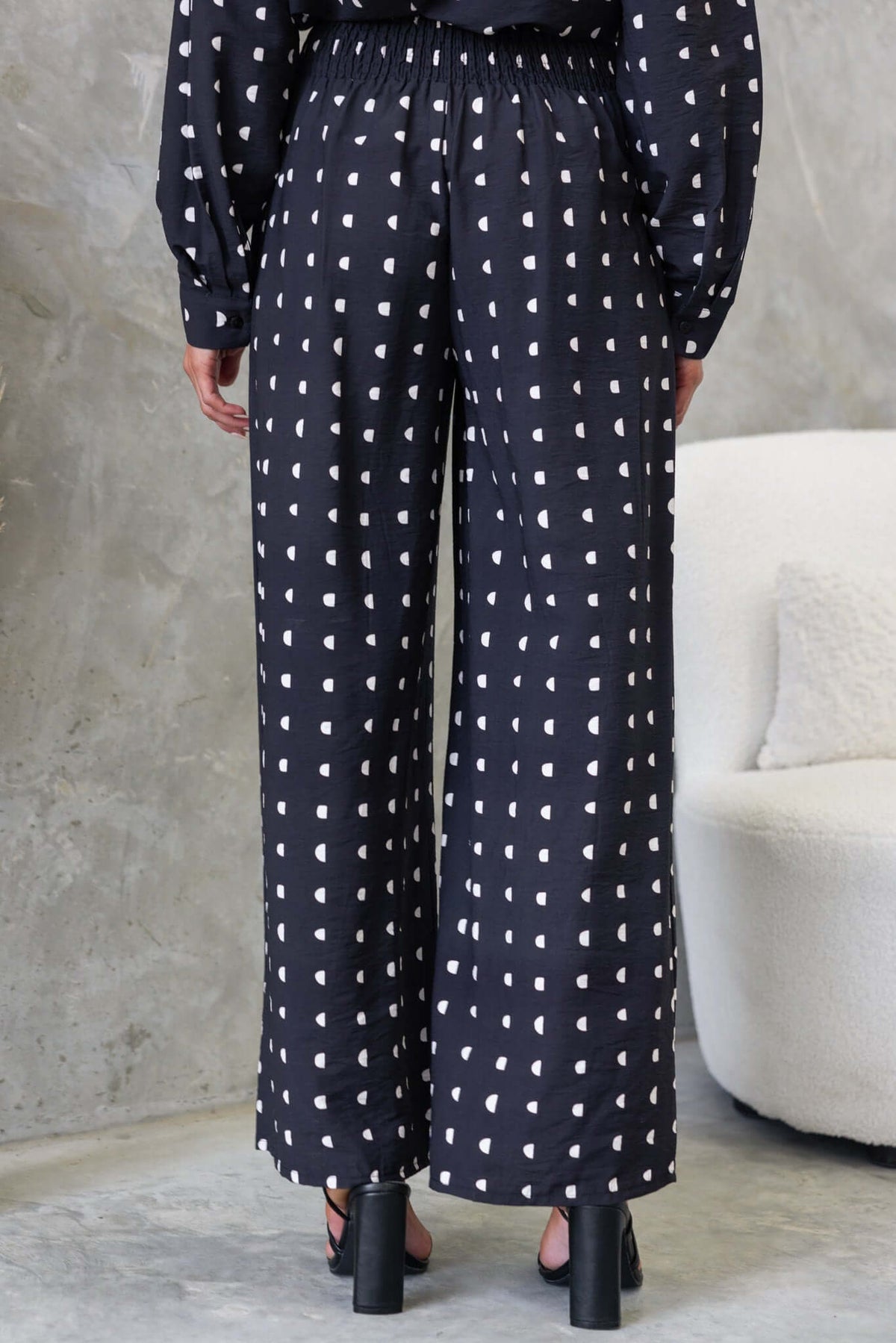 Rear view of Marion Pants featuring a high-waist design, elastic back, and a stylish polka dot pattern.