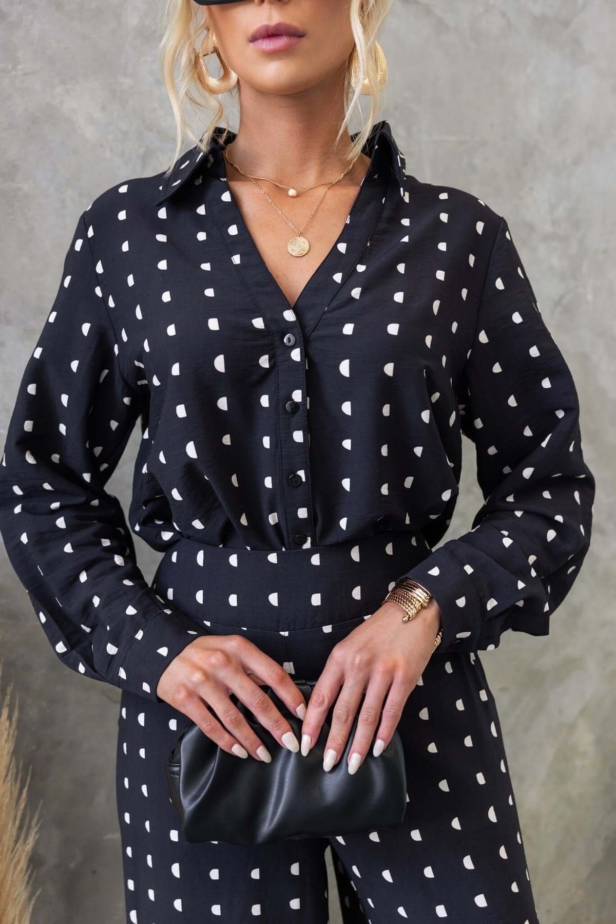 Black Marion shirt with white heart print, button-up front, worn with a black clutch, styled for a chic look.