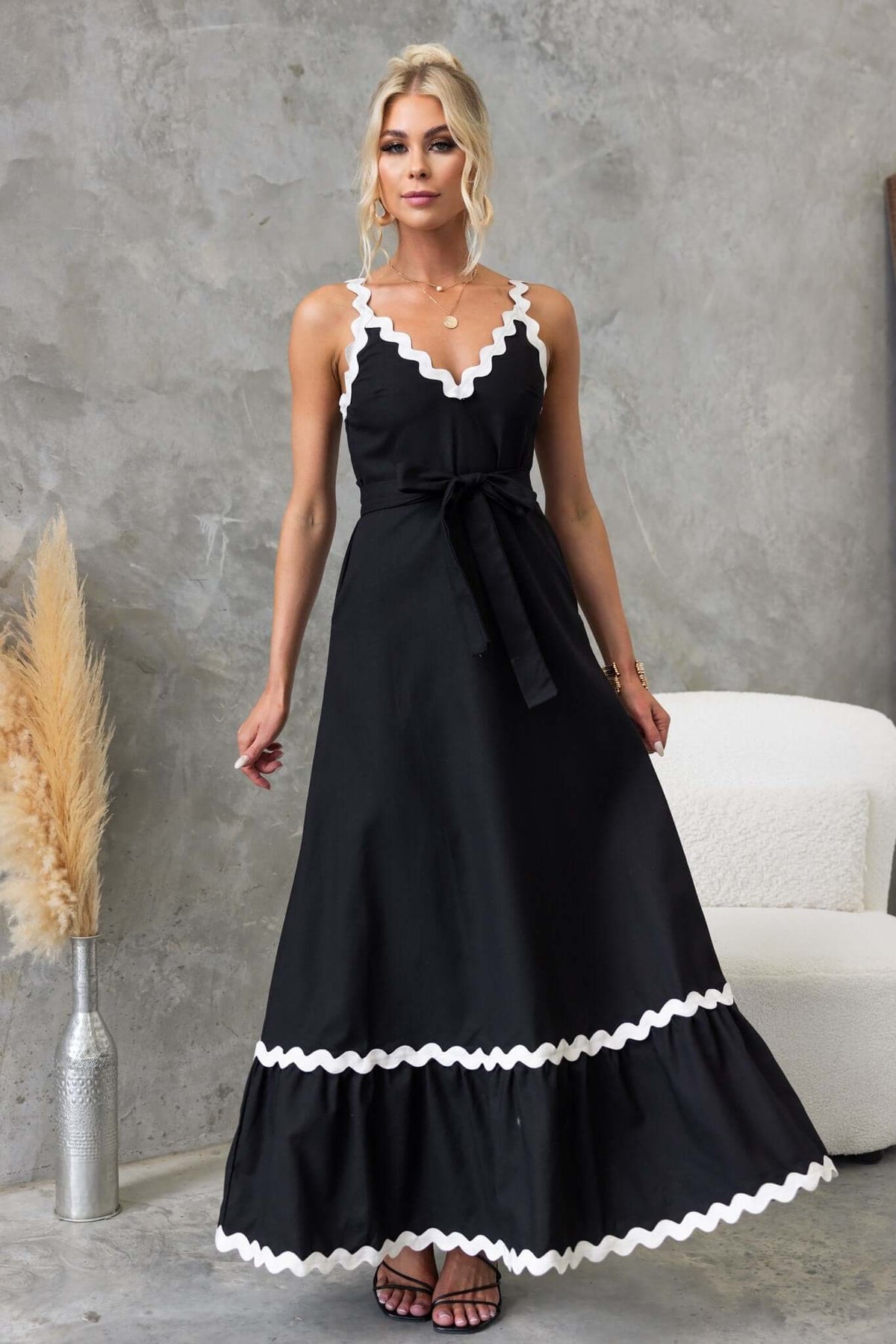 Elegant black Thorelle maxi dress with V-neckline, removable tie, and white trim, perfect for any occasion.
