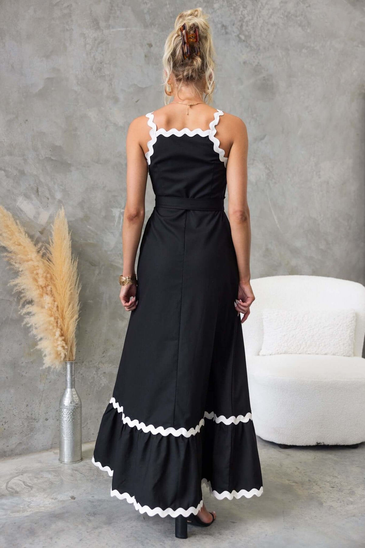 Back view of Thorelle Maxi Dress featuring scalloped edges and a flowing black design, ideal for elegant summer outings.