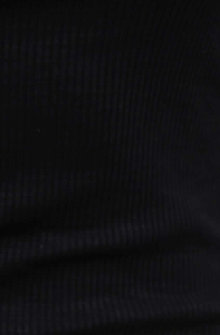 Close-up of the ribbed black fabric of the Genna Midi Dress, showcasing its stretchy material and texture.