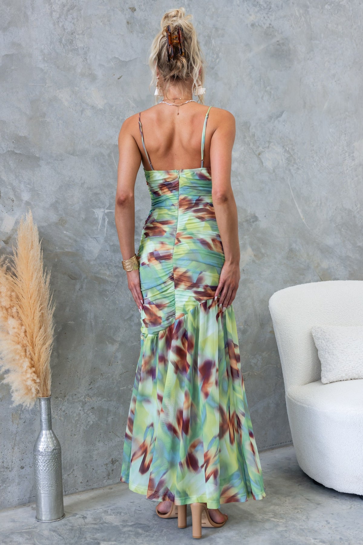 Back view of a model wearing the Comiso Maxi Dress with cowl neckline and adjustable straps in a colorful mesh material.