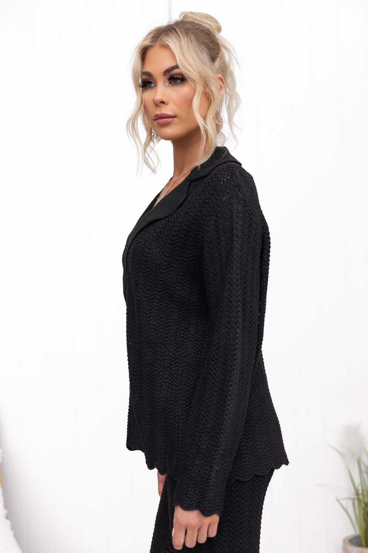 Model wearing a black semi-open weave Moline shirt with a collar and button-up front, showcasing a relaxed fit.