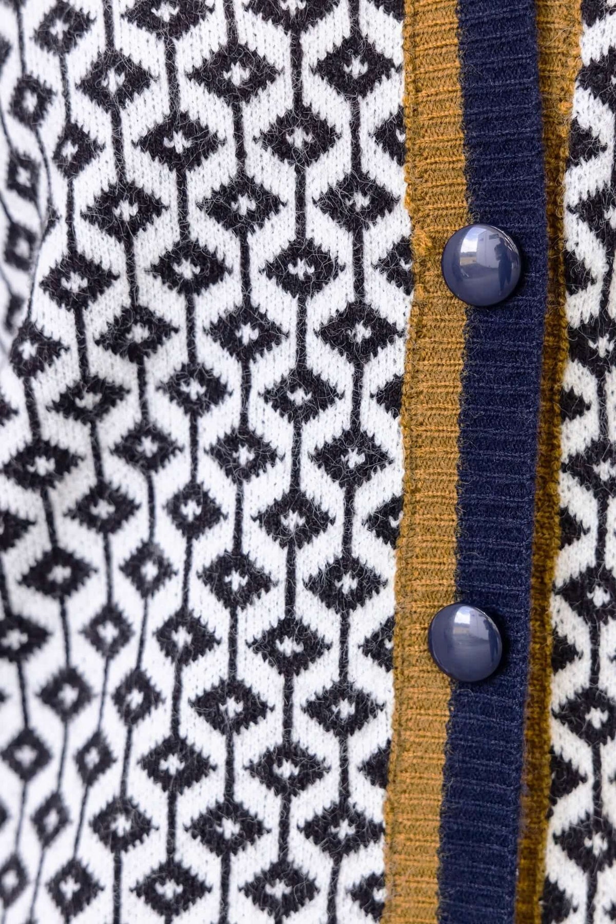 Close-up of Clanton Cardigan featuring a V-neckline, button-up front, and a stylish geometric pattern in black and white.