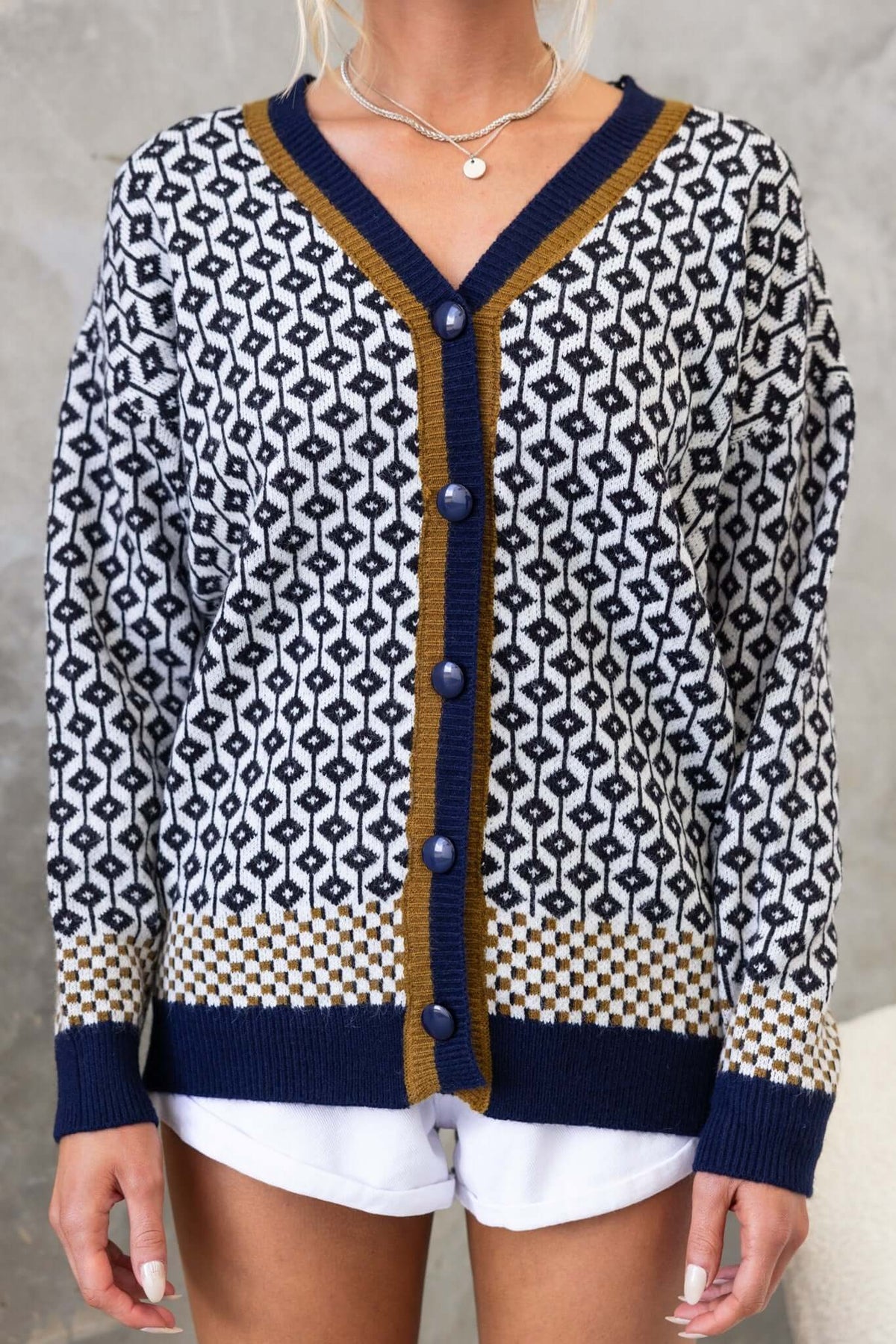 Clanton Cardigan with V-neckline, button-up front, and knitted design in navy and mustard colors.