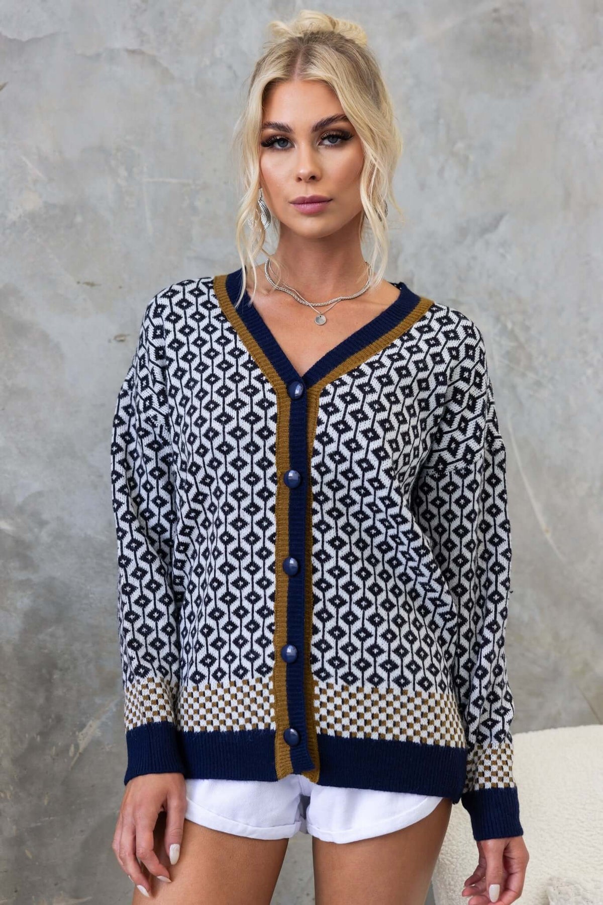 Clanton Cardigan featuring a V-neckline, button-up front, knitted texture, and relaxed fit, styled with shorts.