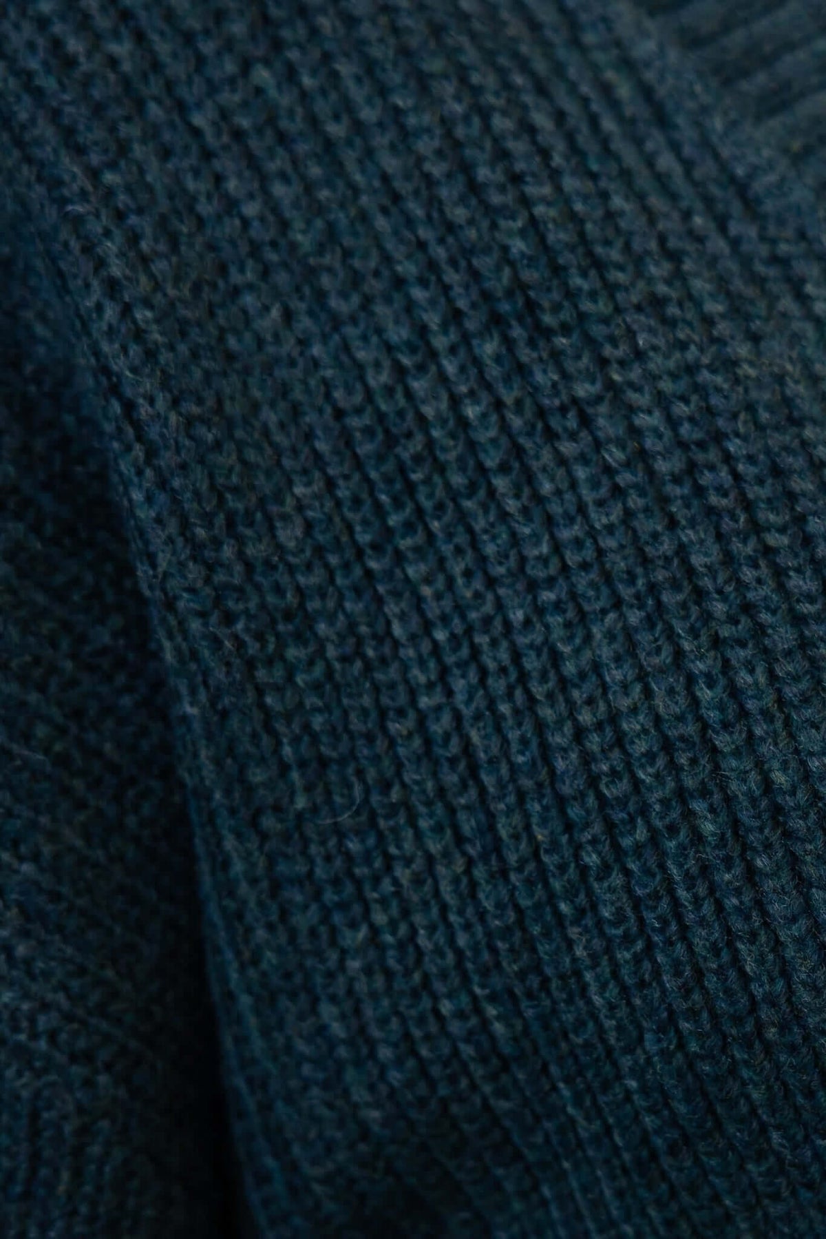 Close-up of dark green knit fabric for the Garland Cardigan, showcasing the textured pattern and acrylic material.