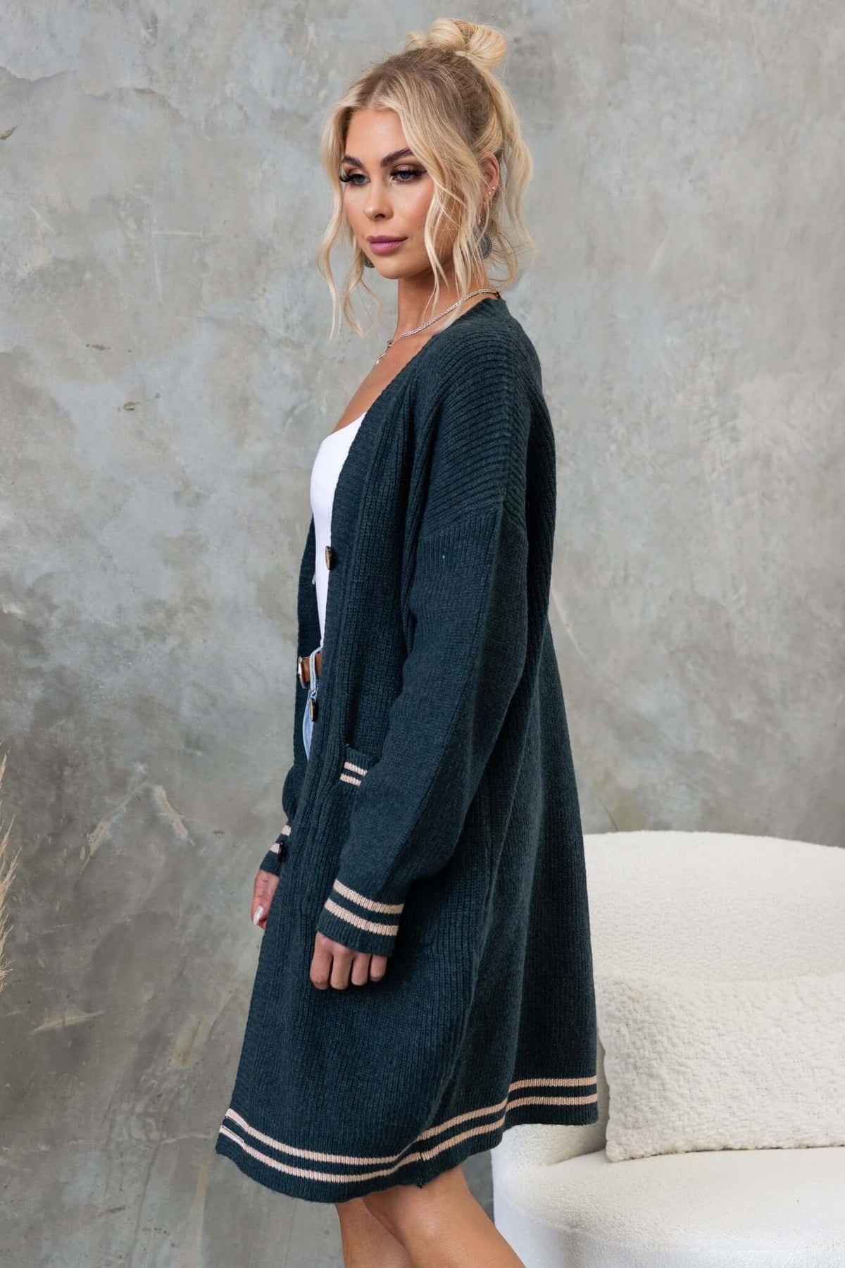 Dark green longline cardigan with v-neckline and button-up front, featuring a relaxed fit and pockets.