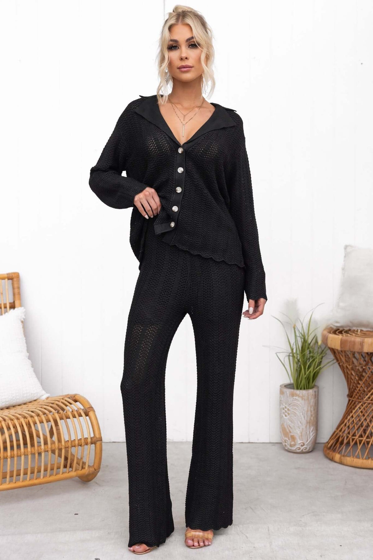 Model wearing a black Moline Shirt featuring a button-up front and relaxed fit, styled with matching pants.