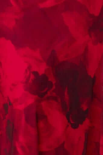 Close-up of the Emiliano Midi Dress showing vibrant red floral fabric with a sheer overlay texture.