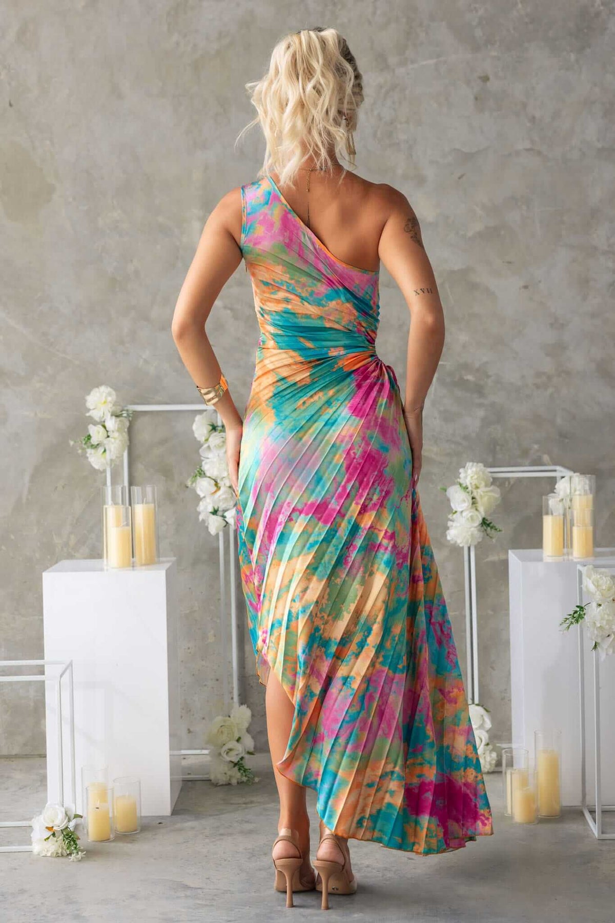 Colorful Tejano maxi dress with one-shoulder neckline and pleated design, perfect for warm-weather occasions.