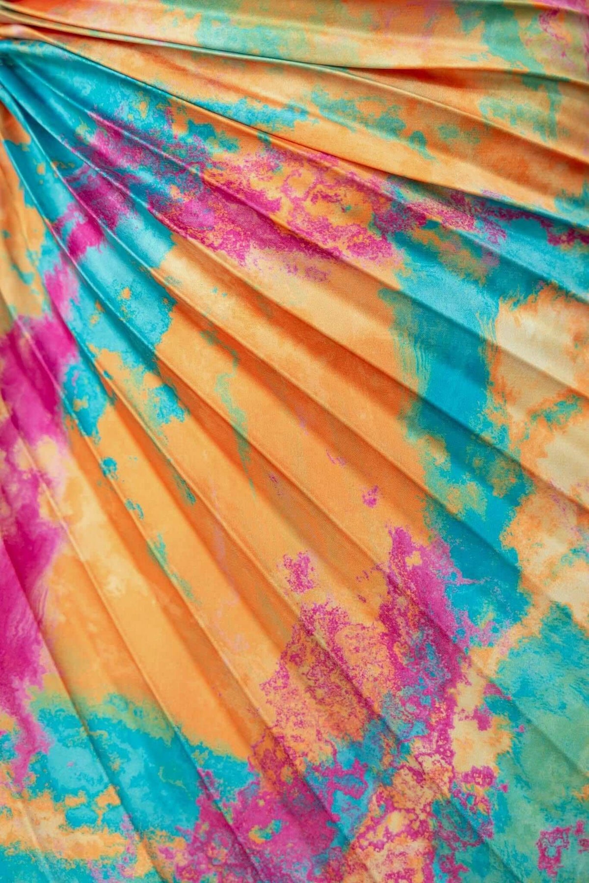 Colorful accordion pleat fabric in vibrant orange, pink, and teal shades, ideal for a stylish maxi dress design.