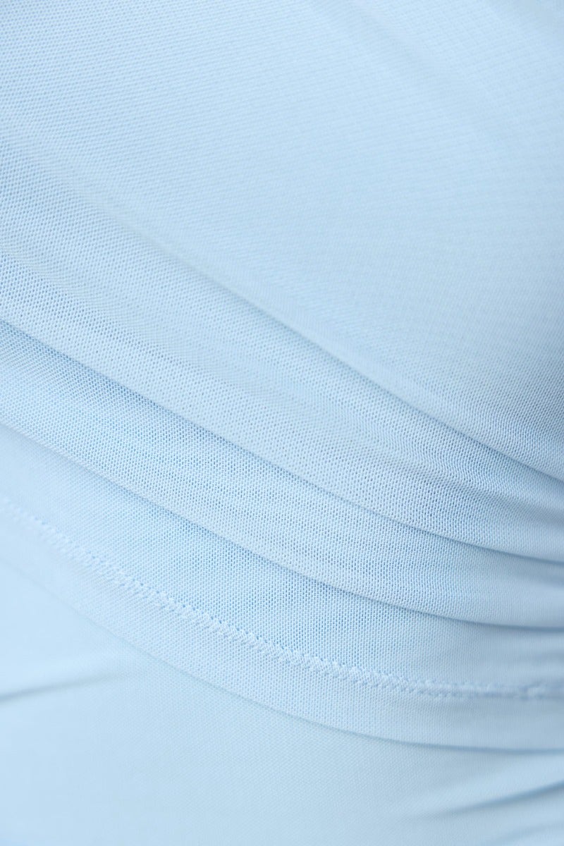 Close-up of light blue fabric with gathered texture, showcasing the soft stretch material of the Feel My Spark Maxi Dress.