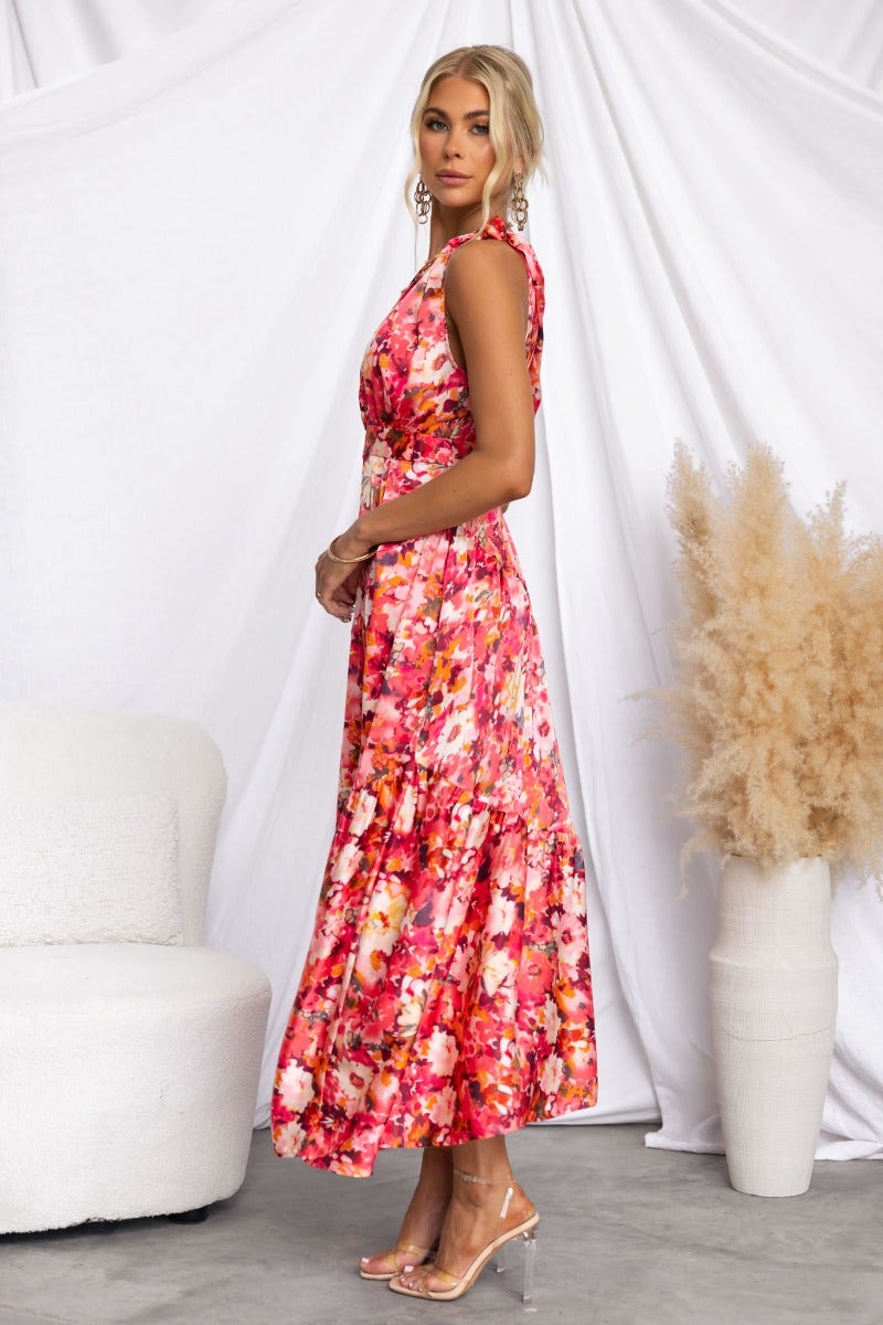 Carmen Midi Dress featuring a floral print, one-shoulder neckline, and pockets, worn by a model in a bright setting.