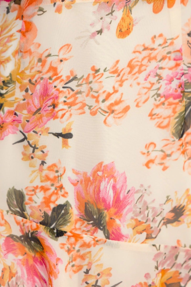 Close-up of floral print fabric featuring vibrant pink and orange flowers on a soft, chiffon material.