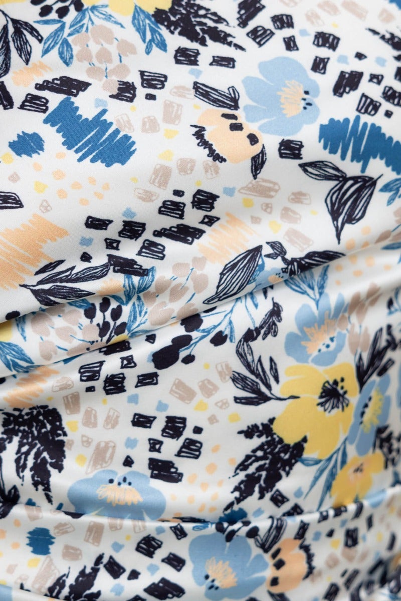Close-up of floral print fabric featuring blue, yellow, and black designs for Dimmi Maxi Dress.