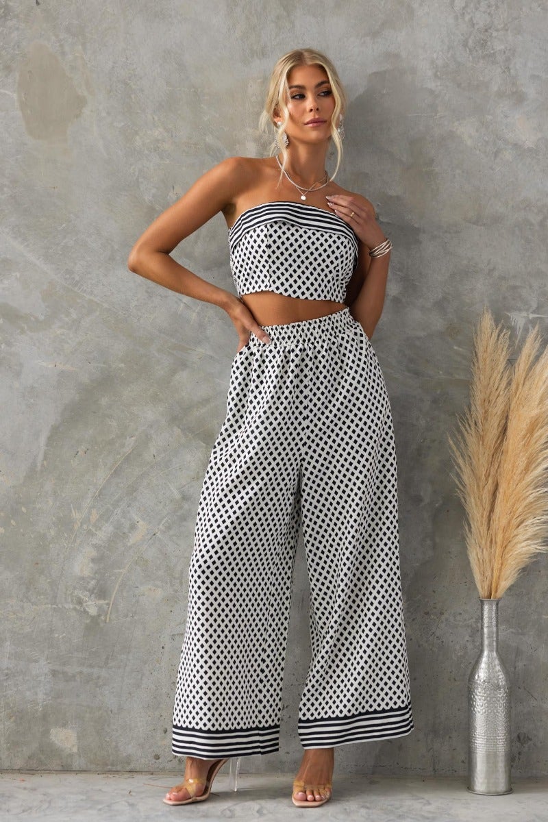 Model wearing Oscar Top, a strapless polka dot top with wide-leg pants, showcasing a stylish summer outfit.