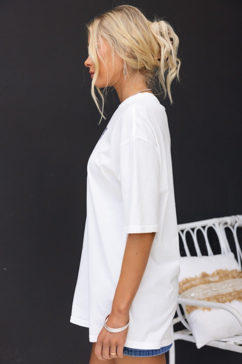 Model wearing oversized white Duke Top tee showcasing round neckline and relaxed fit.