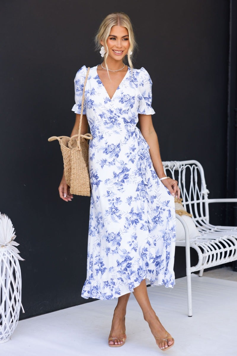Oceanside Wrap Midi Dress in white floral print, featuring a V-neckline and high-low hem, perfect for summer outings.