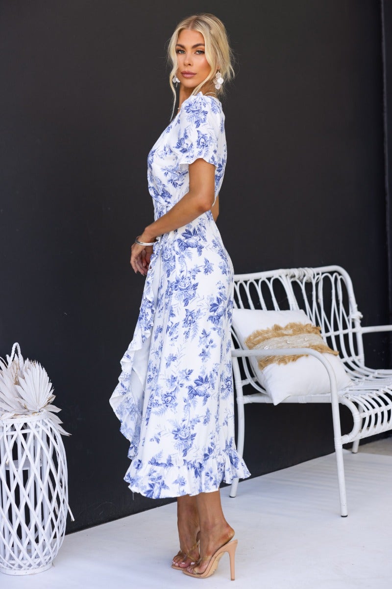 Model wearing Oceanside Wrap Midi Dress with V-neckline and high-low hem against a black backdrop.