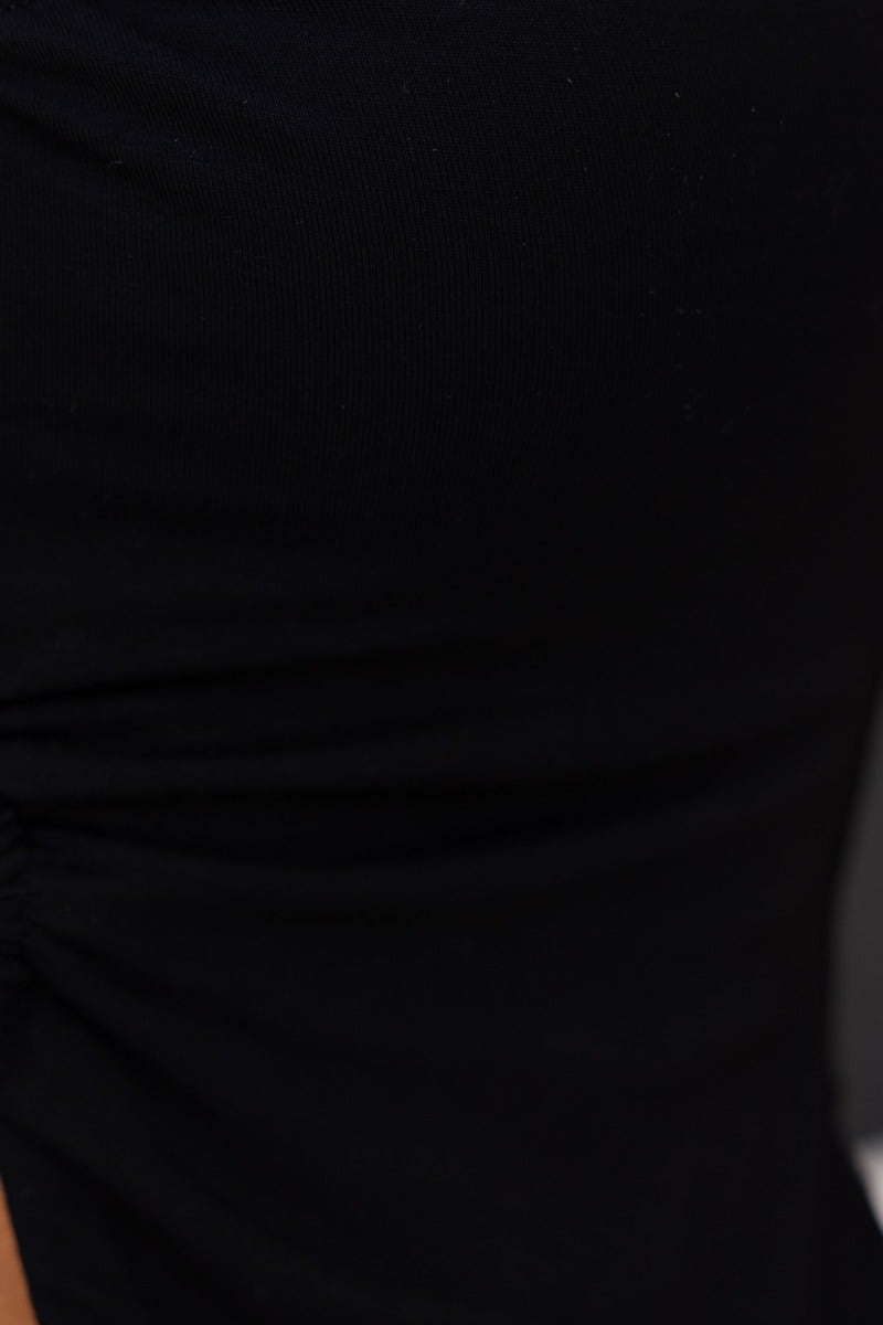 Close-up of a black top featuring soft fabric and side ruching, ideal for stylish, comfortable wear.