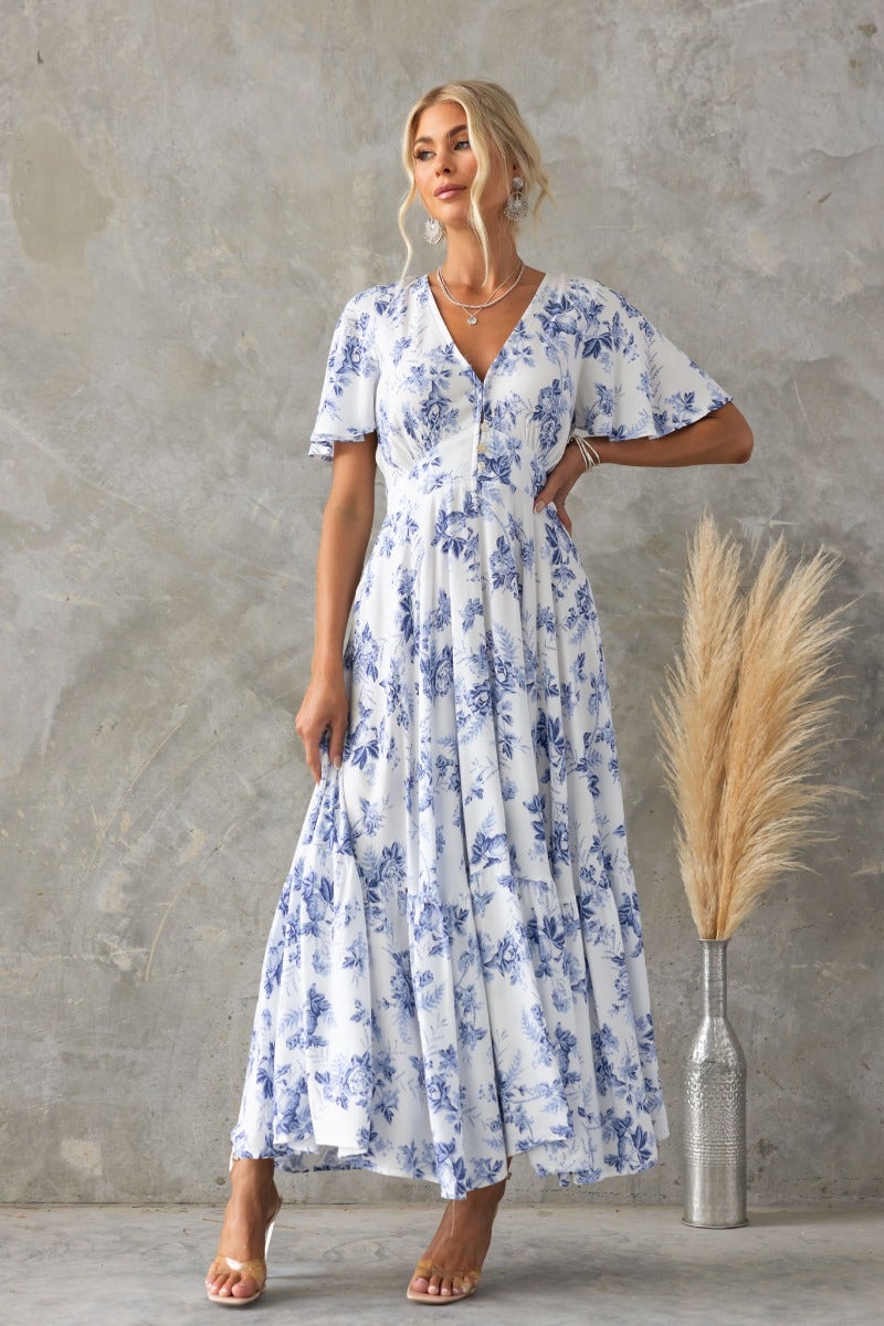 Floral print Nashville maxi dress with V-neckline and buttons, styled with a minimalist decor backdrop.