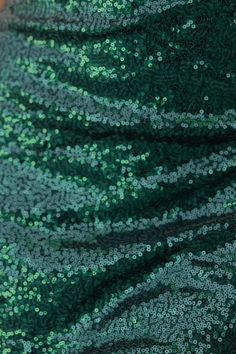 Close-up of shimmering green sequins on a dress, highlighting the luxurious texture and sparkle.