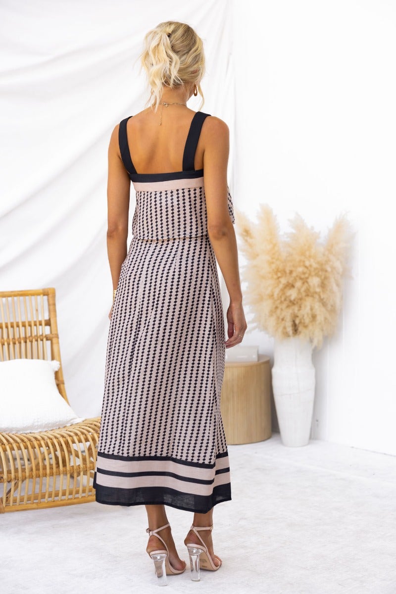 Back view of a woman wearing the Day By Day Set, featuring a square neckline and a mid-high waist midi skirt.