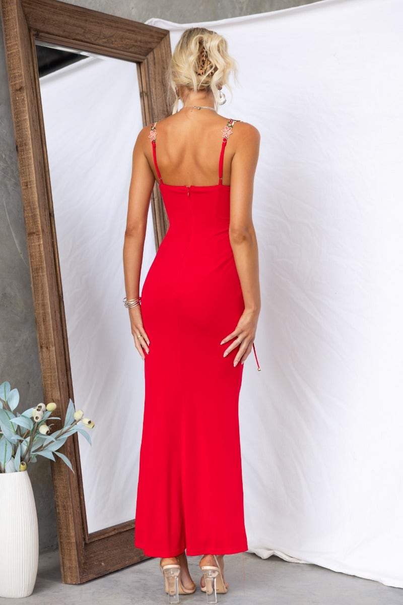 Back view of a red bodycon maxi dress with adjustable straps and floral embroidered details.