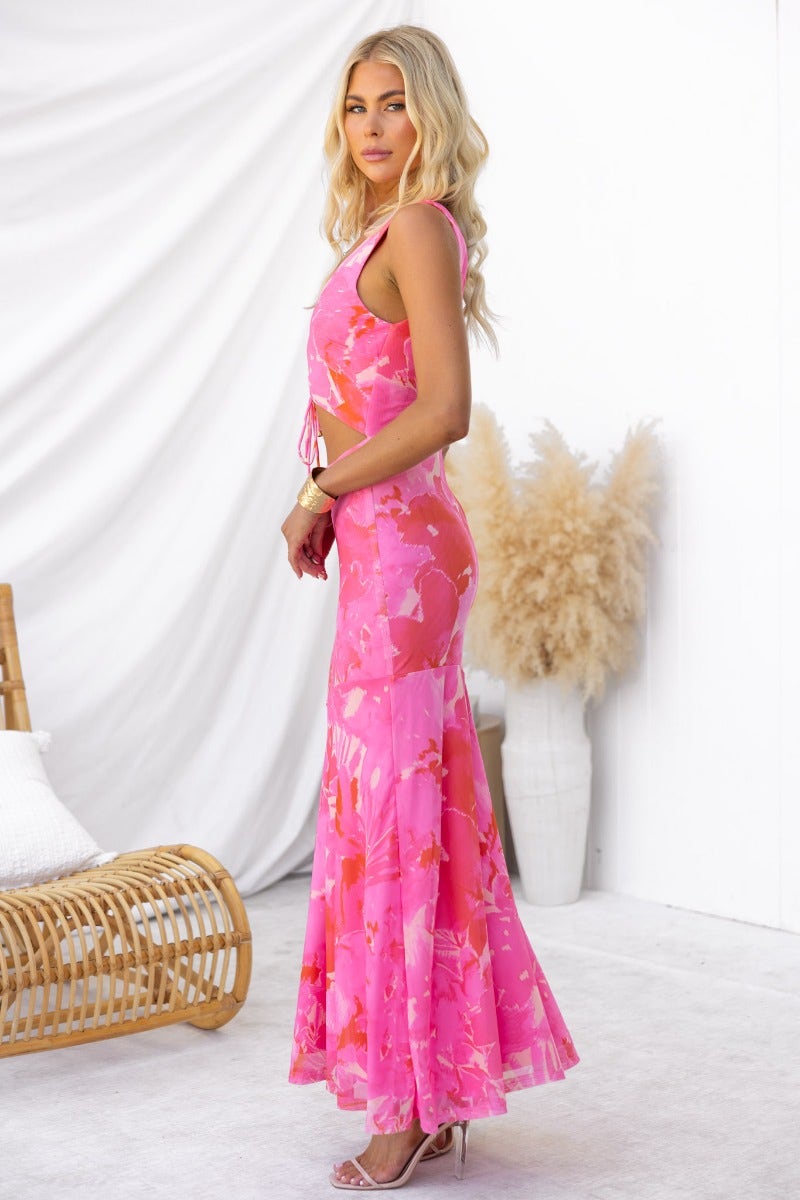 Model wearing a multi-colour pink Pisces maxi dress with a V-neckline and tie detail at the bust.