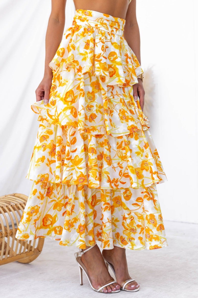 Floral print illusion maxi skirt with ruffle layers in vibrant yellow and white, perfect for summer styling.