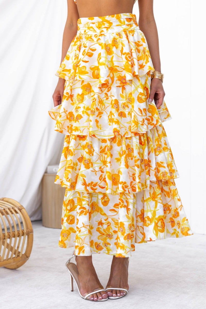 Floral print Illusion Maxi Skirt with ruffles, mid-high waist fit, and a vibrant yellow pattern.