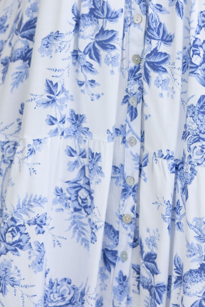 Close-up of floral print fabric on Morea Maxi Dress, featuring blue flowers and button detailing.