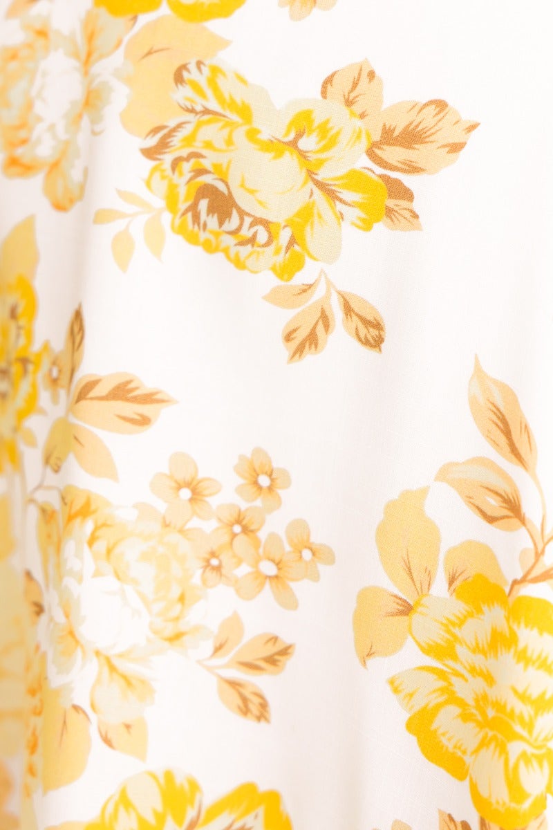 Floral print fabric in shades of yellow and cream, showcasing intricate flower designs for a dress.