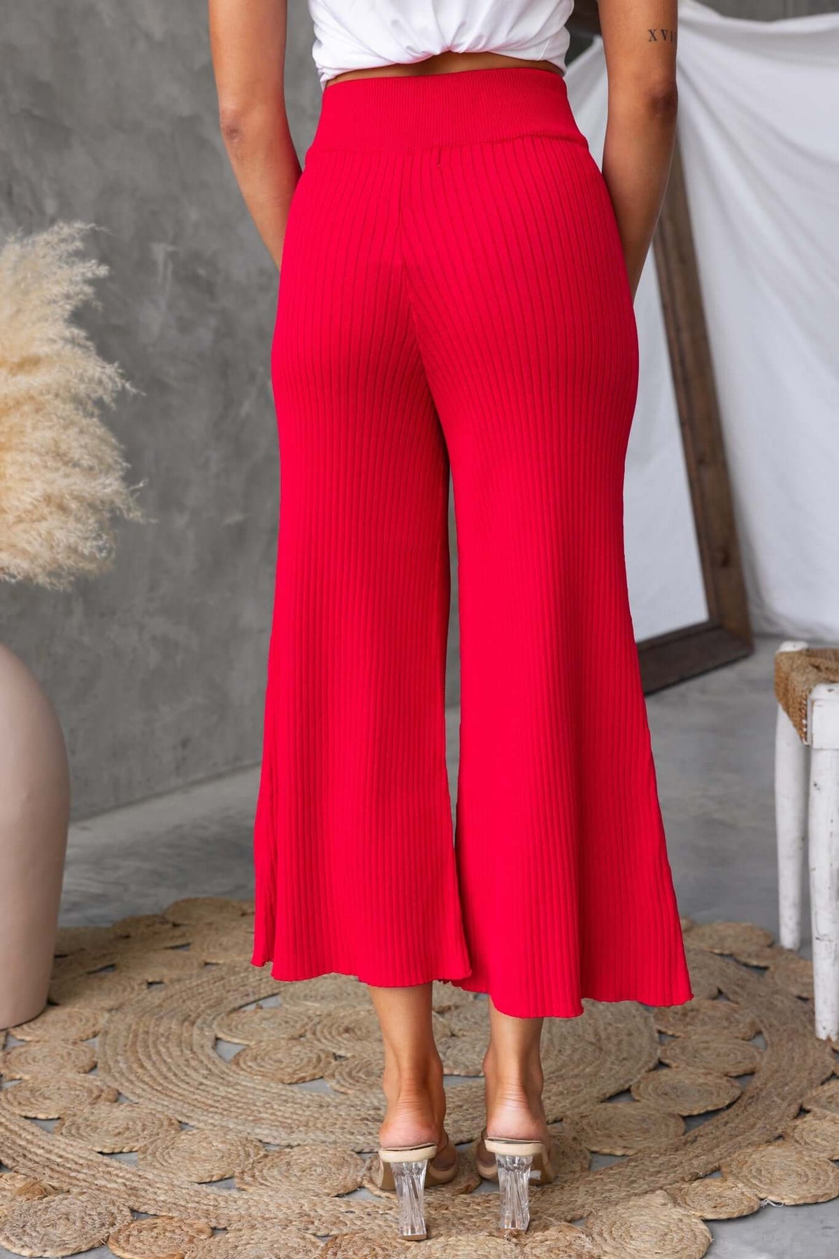 Back view of Dipsie Pants in vibrant red, showcasing ribbed knit fabric and mid-high waist design.