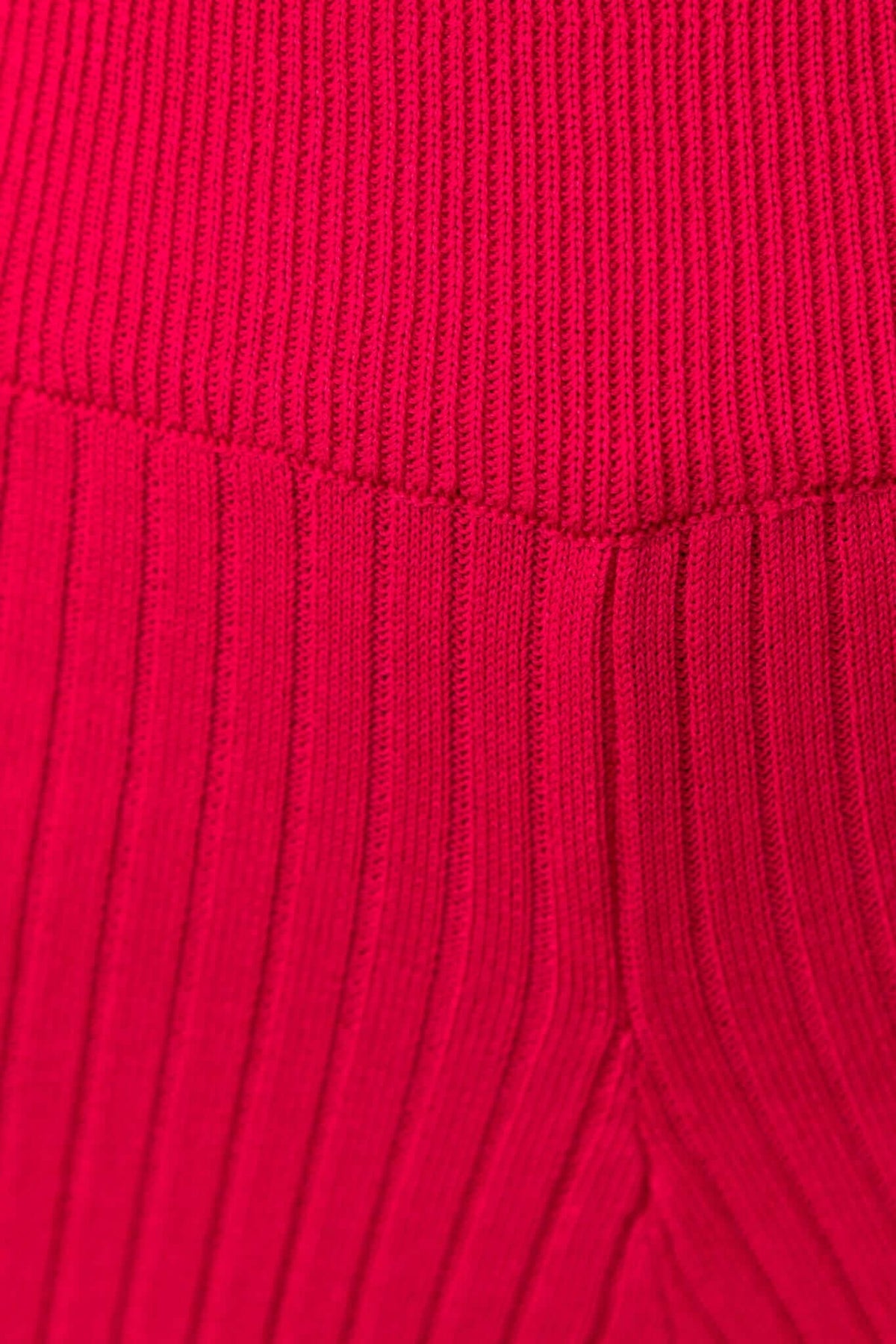 Close-up of ribbed knit material in vibrant red, showcasing stretch and texture for Dipsie Pants.
