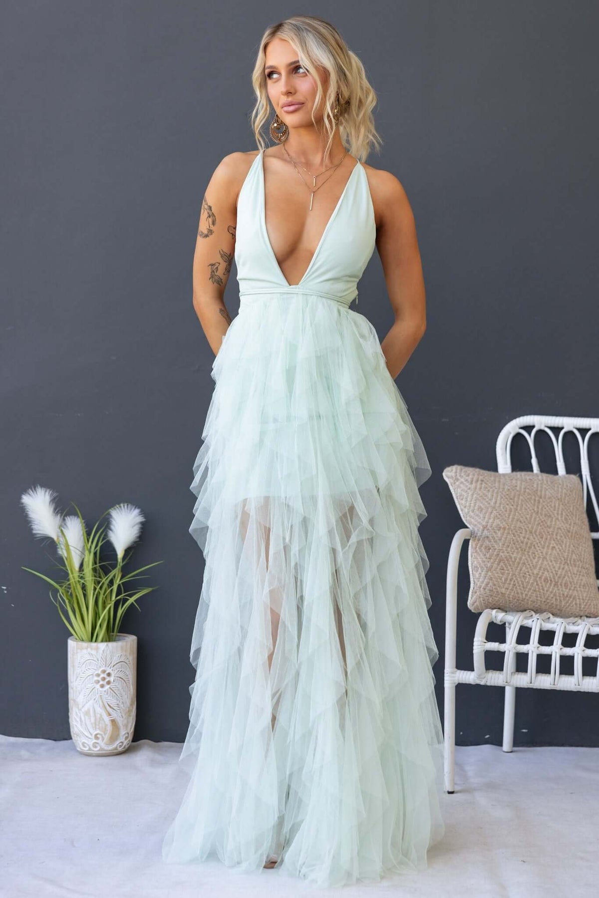 Model wearing a mint green Salinas Maxi Dress with a V-neckline and tulle ruffle skirt, styled elegantly.