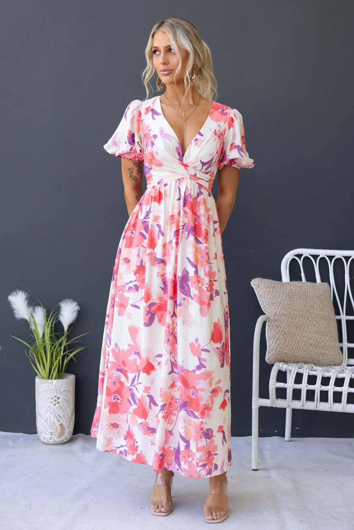 Tinsley Maxi Dress with V-neckline and floral pattern, worn by model against a dark background, showcasing feminine style.
