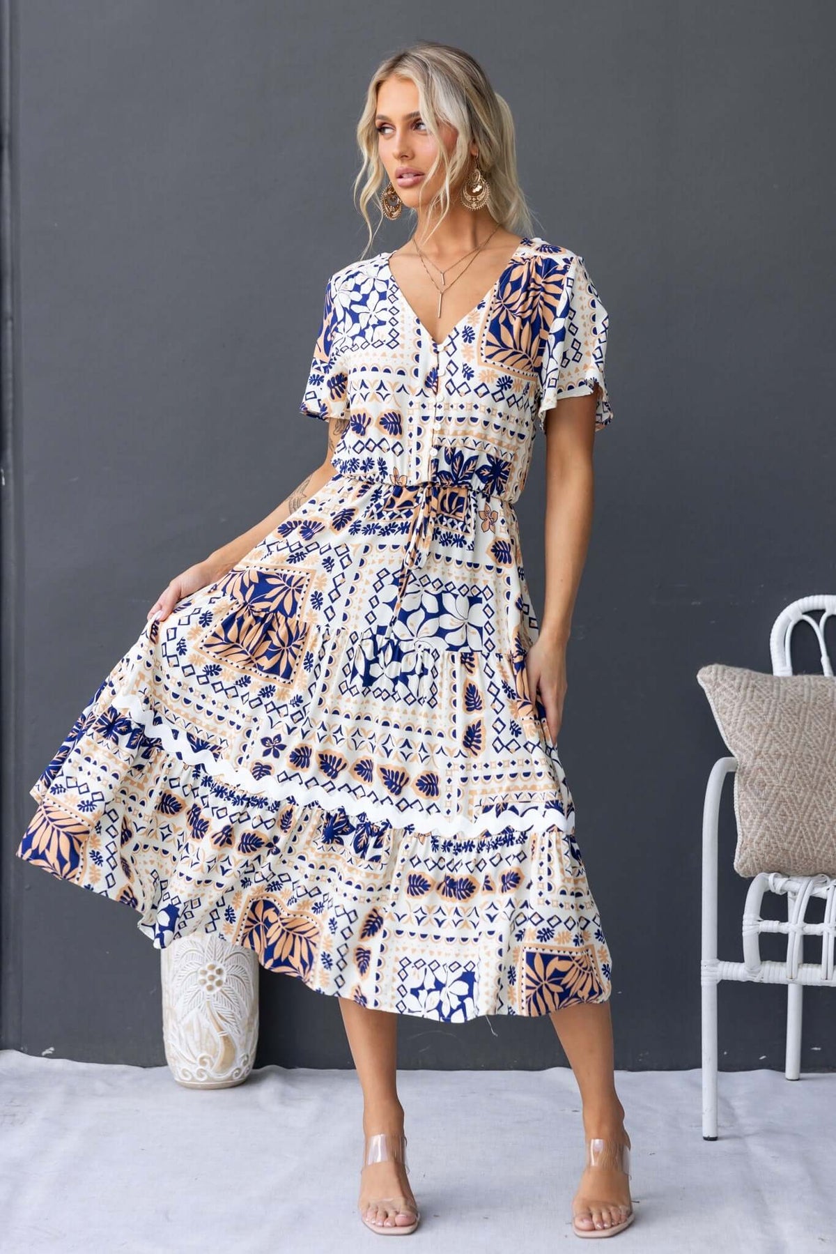 Virden Midi Dress featuring a V-neckline, button-up bust, and elastic waistband, styled with a floral print.