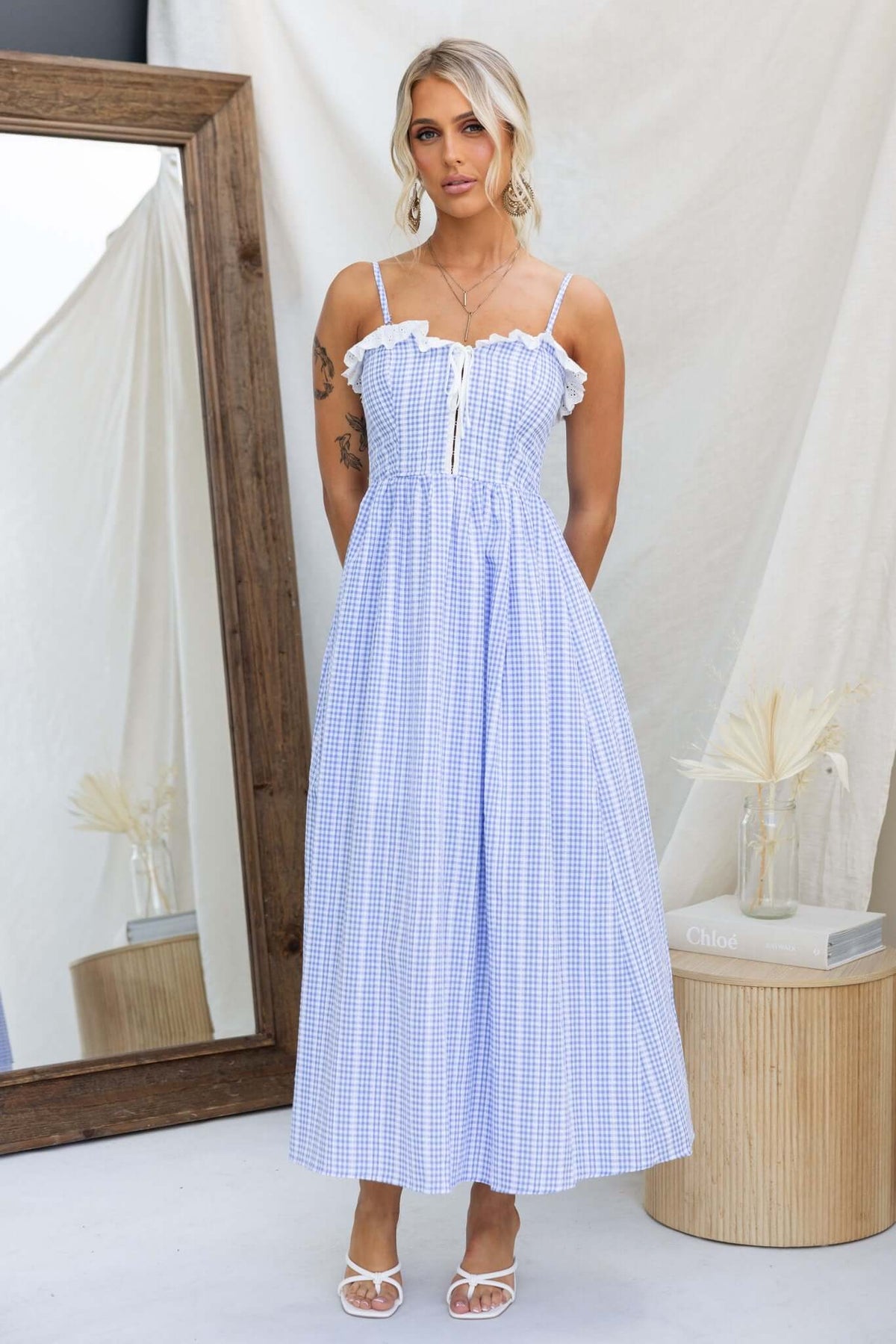 Endlessly Maxi Dress featuring adjustable straps and a playful check pattern, displayed by a model in a stylish indoor setting.