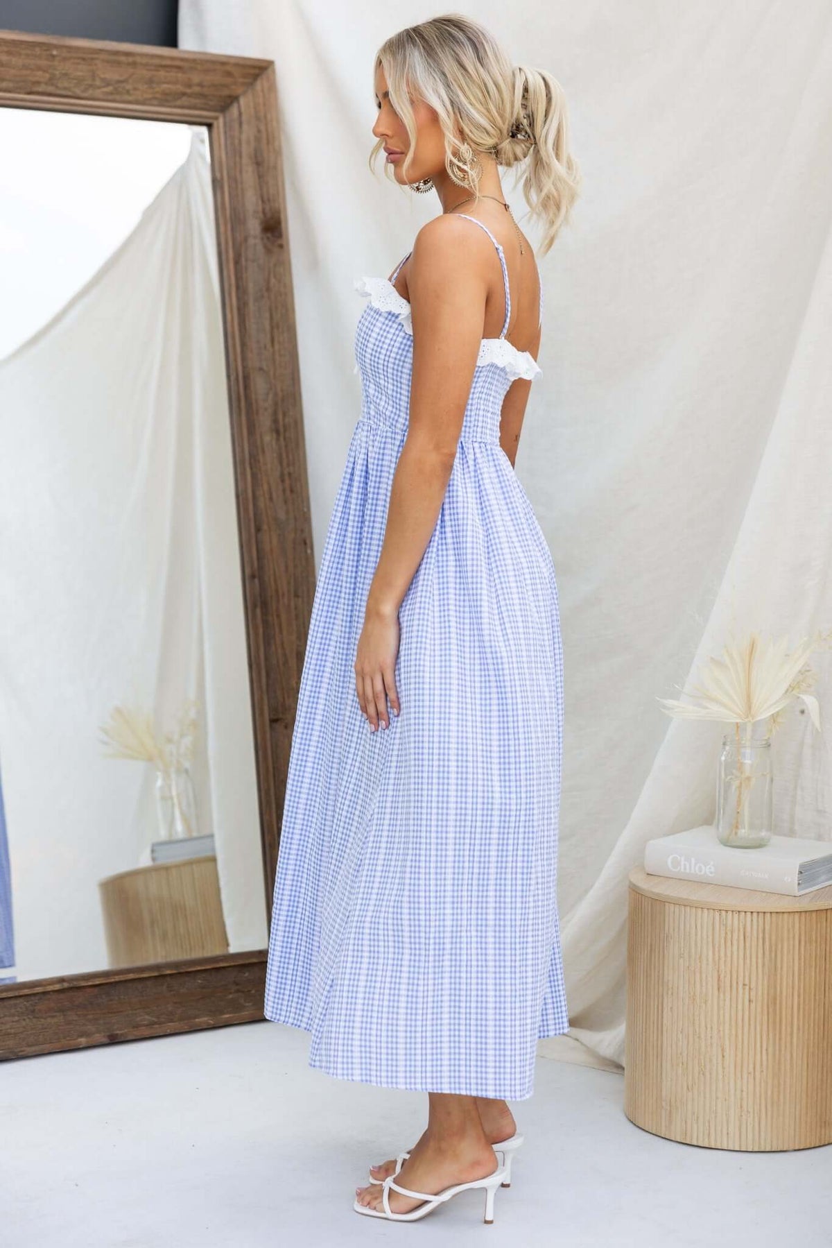 Model side view of Endlessly Maxi Dress in blue gingham, featuring adjustable straps and a flowing design.