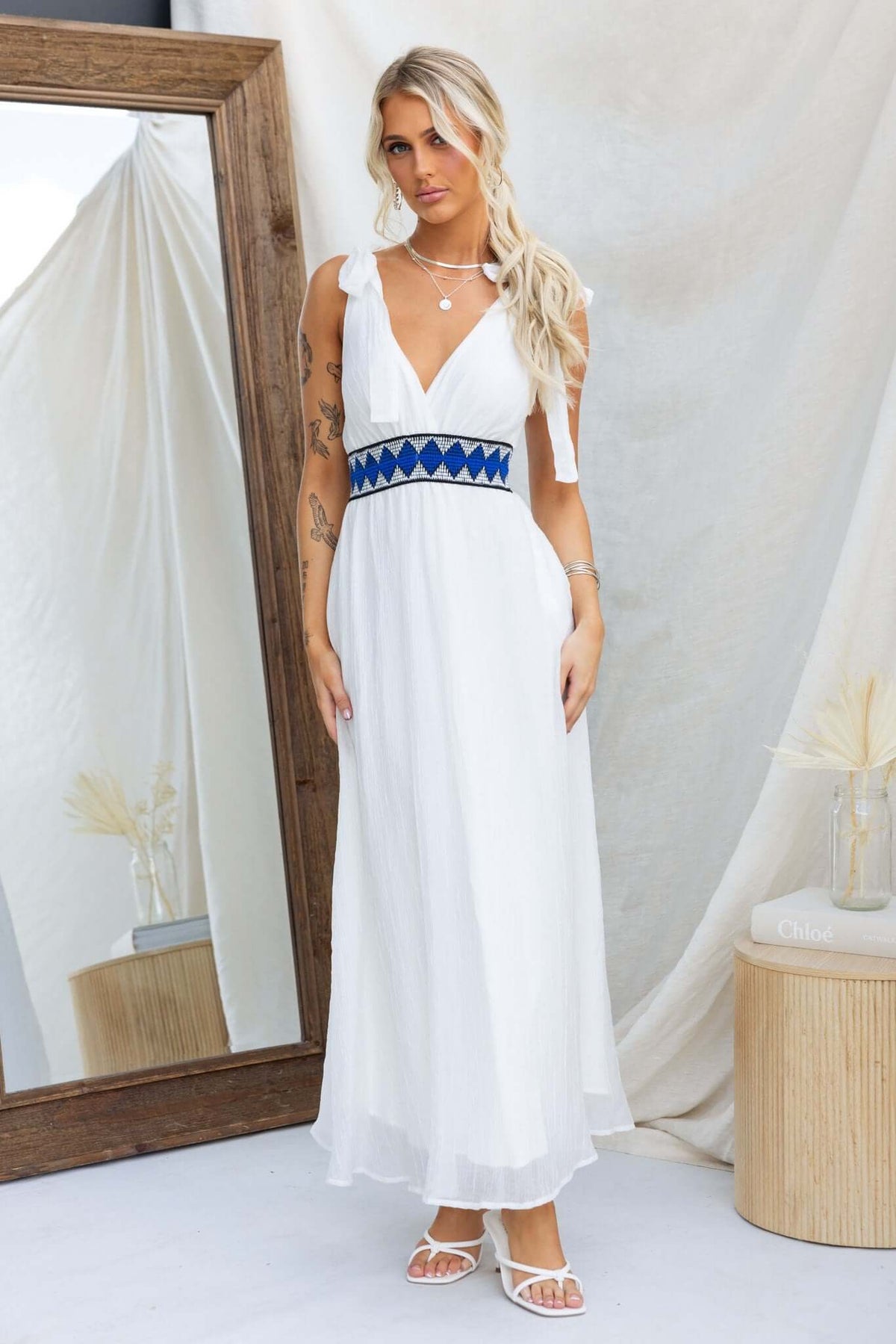 Model wearing an Egret Maxi Dress with tie straps and an elastic waistband, styled with blue detailing.