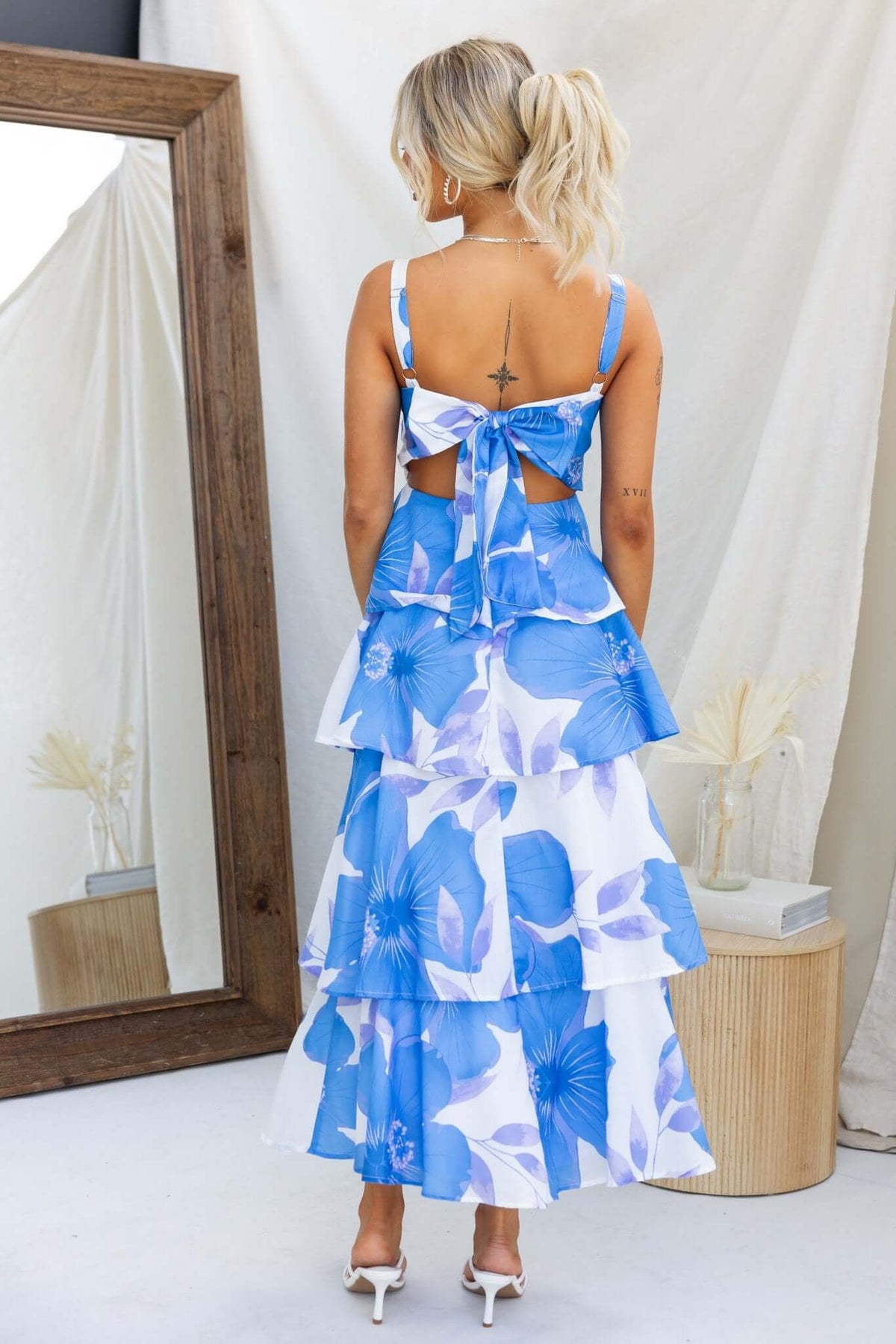 Back view of the Peyton Maxi Dress featuring blue floral print, adjustable straps, and a tiered ruffle skirt.