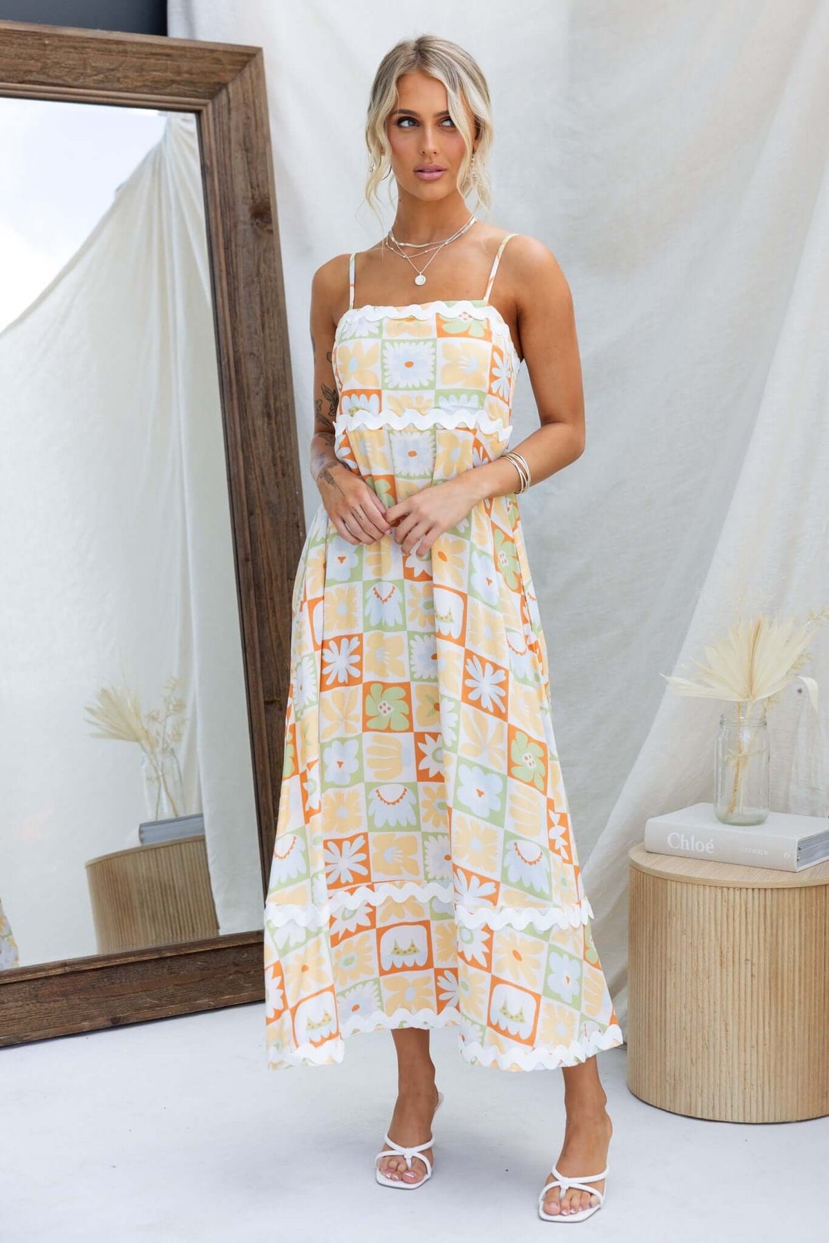 Nekoda Midi Dress with adjustable straps and pockets, modeled by a woman in a vibrant printed style.