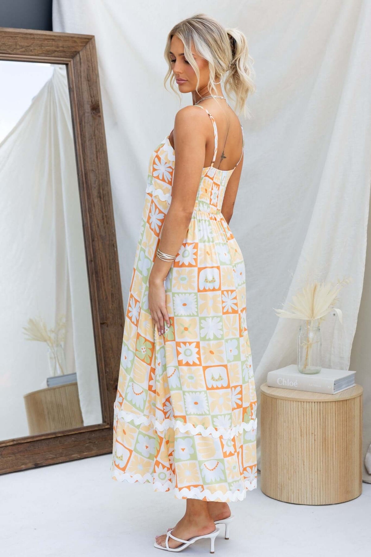 Woman wearing Nekoda Midi Dress in floral pattern, showcasing adjustable straps and pockets, styled with sandals.