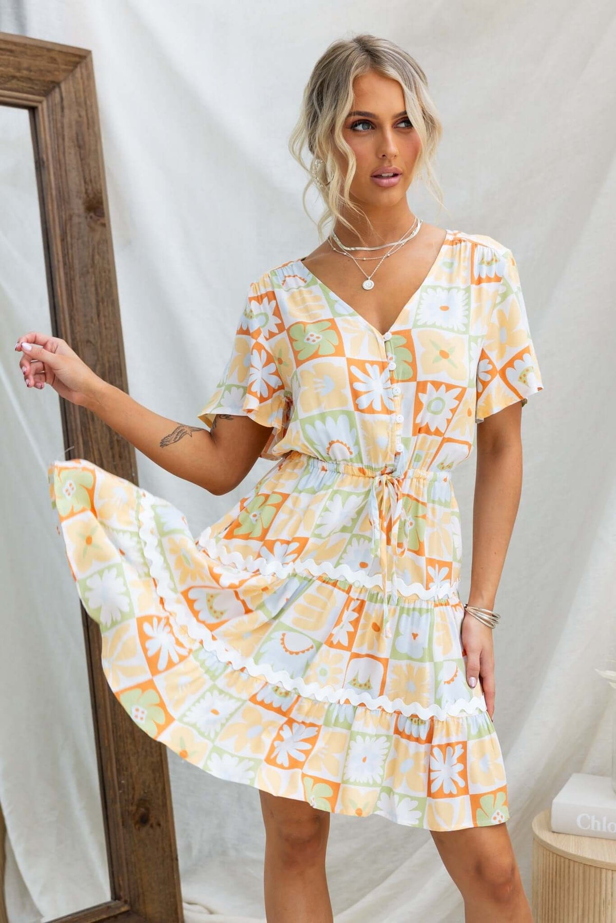 Virden Dress featuring V-neckline, button-up bust, elastic waistband, and pockets in a colorful floral print.