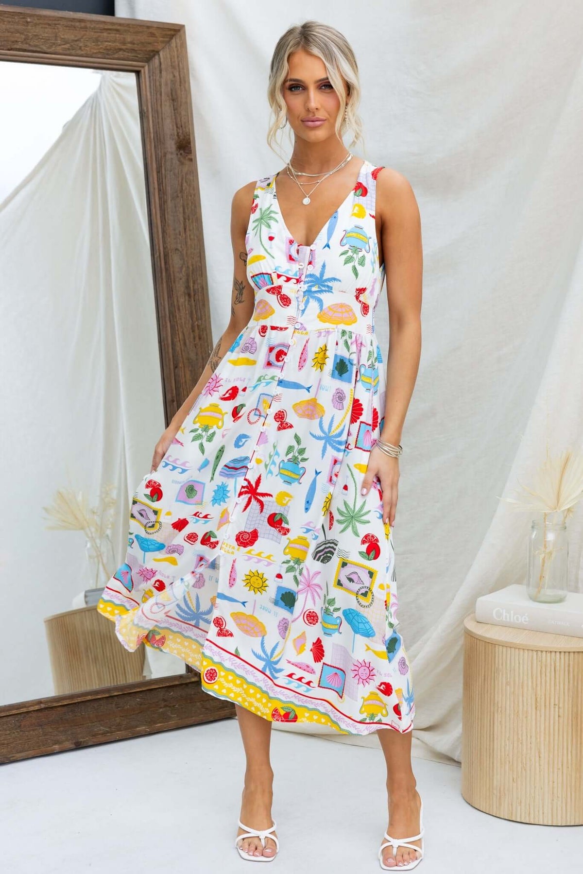 Stylish woman in a colorful Juvena Midi Dress with V-neckline and pockets, perfect for summer outings.