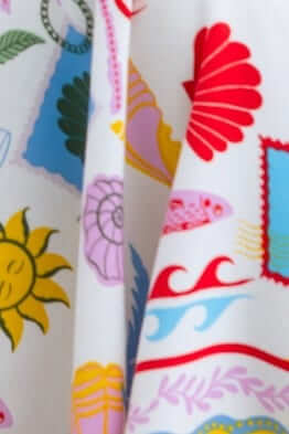 Colorful print featuring seashells, waves, and sunshine on Juvena Midi Dress fabric.